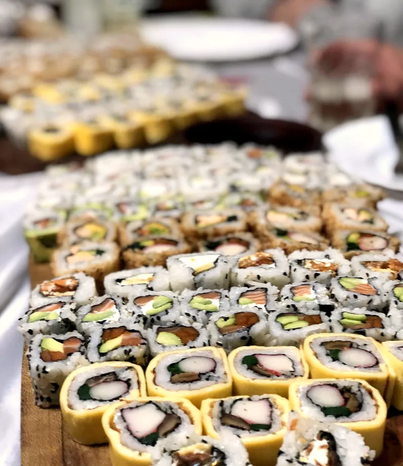 Bandeja enorme de rolls variados terminados, algunos envueltos en tamago