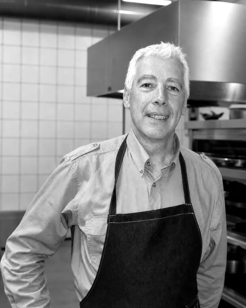 Carlos, de GLUP!, sonriendo con delantal de jean en una cocina