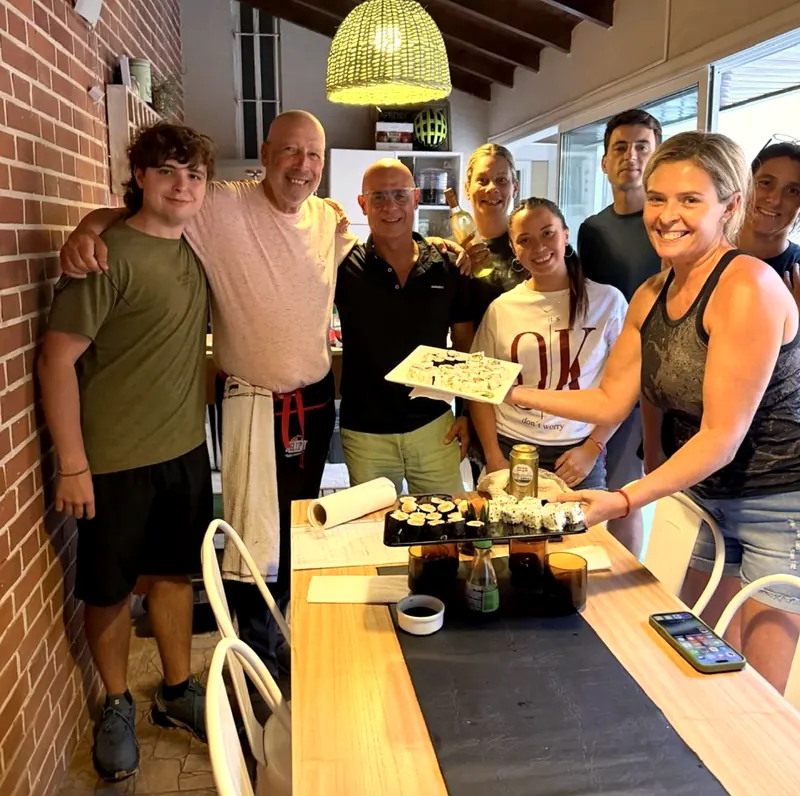 Grupo de alumnos con Carlos posando junto a la mesa con los rolls que prepararon